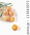 Fresh unpeeled oranges placed in reusable white mesh bag 113643071