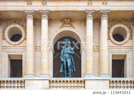A statue of Napoleon stands prominently in a niche at Les Invalides, Paris, framed by ornate architecture 113643831