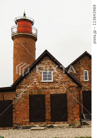 A brick building featuring a lighthouse atop, against the backdrop of the sky 113643989