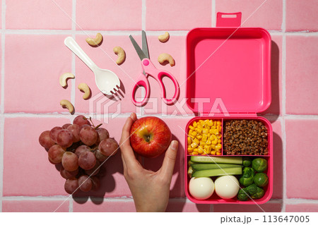 Pink lunch box with food and fresh fruits Pink lunch box with food and fresh fruits 113647005