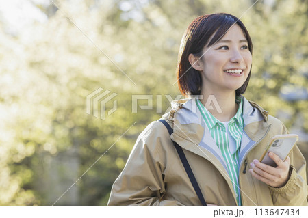 屋外でスマホを見る女性 113647434