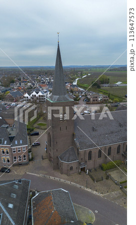 Beautiful view from above, from drone to orange, tiled roofs of houses. Top view of the Dutch city of Wijk bij Duurstede. The streets and roof of the church. Central Square of the city. Beautiful view from above, from drone to orange, tiled roofs of houses. Top view of the Dutch city of Wijk bij Duurstede. The streets and roof of the church. Central Square of the city. 113647573