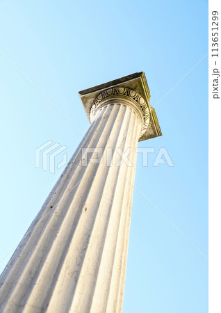 One tall antique marble column placed diagonally against the blue sky Focus on the end of the column Vertical photo One tall antique marble column placed diagonally against the blue sky Focus on the end of the column Vertical photo 113651299
