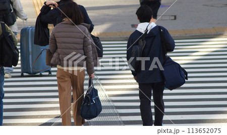 冬の朝の街の交差点の横断歩道を渡る人々の姿 冬の朝の街の交差点の横断歩道を渡る人々の姿 113652075