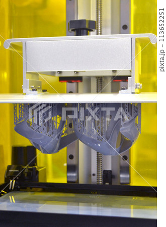 Process SLA 3D printing. Process printing on 3D printer by SLA printing technology. 3D printed object from resin polymerization. Object created on 3D printer from hardened resin. Printing technology Process SLA 3D printing. Process printing on 3D printer by SLA printing technology. 3D printed object from resin polymerization. Object created on 3D printer from hardened resin. Printing technology 113652251