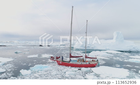 Sailing Yacht Sail in Antarctic Iceberg Ocean Aerial Tracking. Red Vessel Expedition to Polar Nature Glacier Calm Harbour Top Drone 113652936
