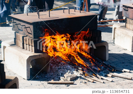 焚き火でサツマイモを蒸している写真。焼き芋の調理過程。 113654731