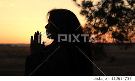 girl woman praying at sunset, hand sunset faith pain, asking heaven for help, spiritual sunset meditation, serene prayer moment, dusk reflection solitude, sunset prayer tranquility, peaceful evening 113654757