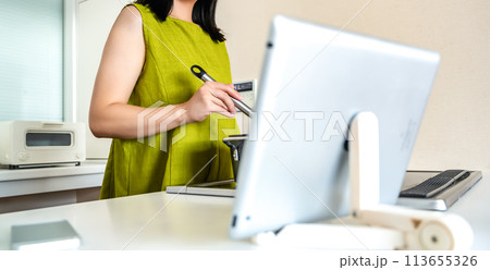 タブレットで動画を見ながら料理をする若い女性のイメージカット 113655326