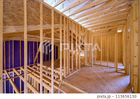New unfinished residential home under construction with framing made of wood supporting beam 113656130