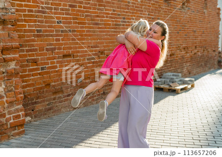 Child girl with cochlear implant with her mother spend time outdoor. Hear impairment and deaf community concept. Deaf and health concept. Diversity and inclusion. Copy space 113657206