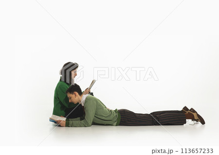 Young couple, man and woman spending time together and reading books isolated on white background. 113657233