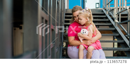 Banner blonde little girl with cochlear implant playing with her mother outdoor. Hear impairment deaf and health concept. Diversity and inclusion. Copy space Banner blonde little girl with cochlear implant playing with her mother outdoor. Hear impairment deaf and health concept. Diversity and inclusion. Copy space 113657278