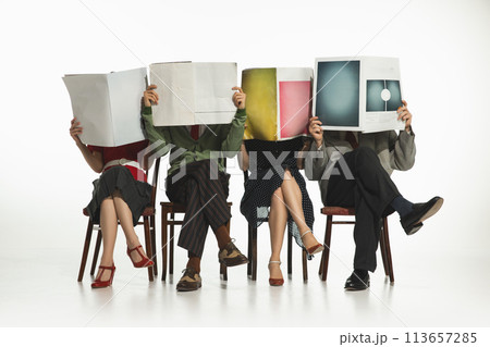 Group of four people, men and women in retro-style clothes sitting on chair and reading newspapers, journals on white background. 113657285