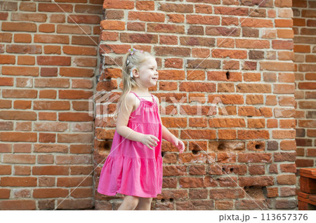 Child girl walks and have fun outdoor with cochlear implant on the head. Hearing aid and treatment concept. Copy space vertical. Inclusion Child girl walks and have fun outdoor with cochlear implant on the head. Hearing aid and treatment concept. Copy space vertical. Inclusion 113657376