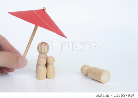Family wooden dolls covered with insurance due to lost of loves one. Insurance concept. Family wooden dolls covered with insurance due to lost of loves one. Insurance concept. 113657914