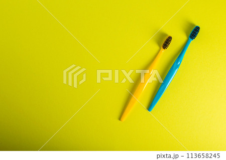 Yellow and blue toothbrush with charcoal coating on a yellow background. The concept of dental and oral hygiene in dentistry. Copy space for text, medium hard. View from above. Prevention of caries, 113658245