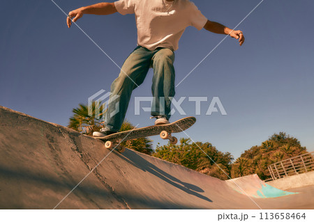 Close up of young man doing tricks on his skateboard at the skate park. Active sport concept 113658464