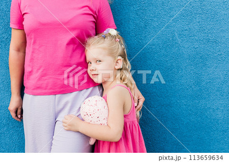 Blonde little girl with cochlear implant playing with her mother outdoor. Hear impairment deaf and health concept. Diversity and inclusion. Copy space Blonde little girl with cochlear implant playing with her mother outdoor. Hear impairment deaf and health concept. Diversity and inclusion. Copy space 113659634
