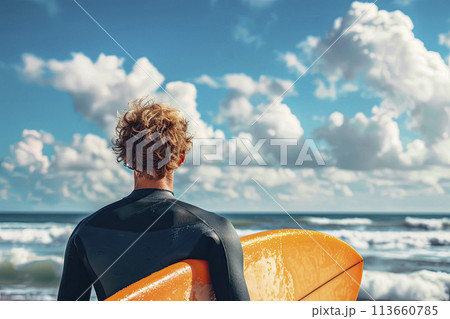 Surfer looks at the ocean while holding his surfboard at the beach. Ai generative 113660785