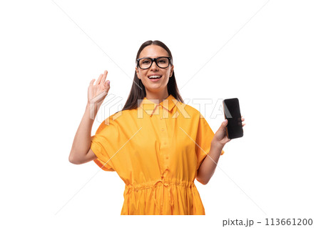 Caucasian young woman with black straight hair wears glasses and a yellow dress 113661200