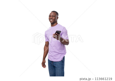 young handsome african man in lilac t-shirt doubts uses smartphone young handsome african man in lilac t-shirt doubts uses smartphone 113661219