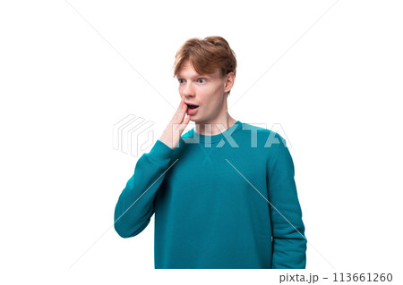 close-up portrait of a student guy with red hair, a guy dressed in a blue sweater looking in 113661260