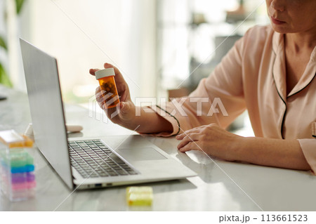 Cropped image of woman showing doctor pills she takes during telemedicine session 113661523