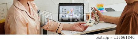 Web banner with husband helping wife to measure blood pressure when video calling doctor Web banner with husband helping wife to measure blood pressure when video calling doctor 113661846