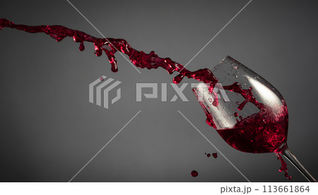 Glass and red wine splash on a dark background. Glass and red wine splash on a dark background. 113661864