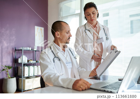 Doctor asking colleague to approve prescription document 113661880
