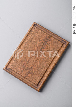Empty wooden cutting board on gray textured concrete background Empty wooden cutting board on gray textured concrete background 113662078