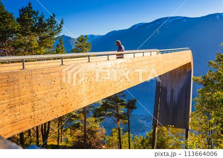 Tourist enjoying fjord view on Stegastein viewpoint Norway Tourist enjoying fjord view on Stegastein viewpoint Norway 113664006