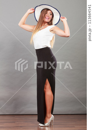 Woman wearing long black white dress and sun hat 113664541