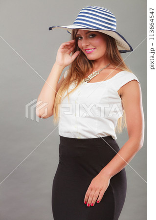 Woman wearing long black white dress and sun hat Woman wearing long black white dress and sun hat 113664547