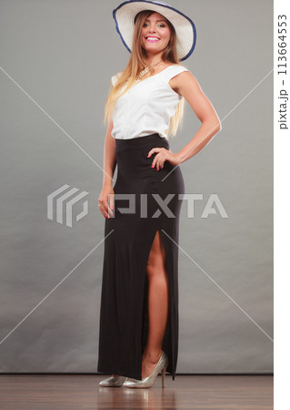 Woman wearing long black white dress and sun hat Woman wearing long black white dress and sun hat 113664553