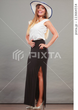 Woman wearing long black white dress and sun hat 113664554