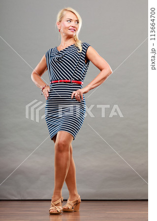 Mid adult woman in summer striped dress Mid adult woman in summer striped dress 113664700