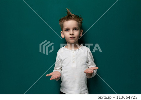 Little Boy Standing in Front of Green Wall 113664725