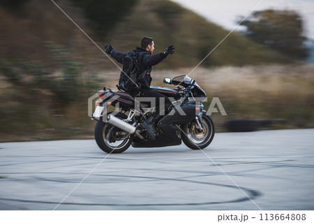 Young biker riding a sport motorbike without hands and feel free Young biker riding a sport motorbike without hands and feel free 113664808