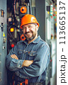 Man in Hard Hat Standing in Front of Control Panel 113665137