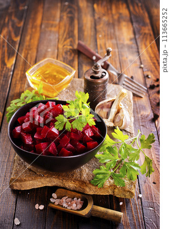 Beetroot salad with parsley in bowl on rustic wooden table. Beetroot salad with parsley in bowl on rustic wooden table. 113665252