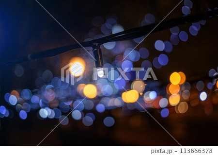 Street garland near view, decoration of the city for the New Year and Christmas holidays. Beautiful blurred lights-bokeh in the background. 113666378