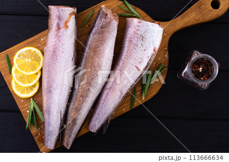 Raw hake on wooden background Raw hake on wooden background 113666634