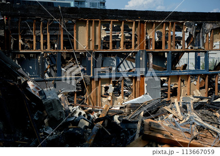 A burnt-out old wooden building after a fire. Charred beams after the destruction. 113667059