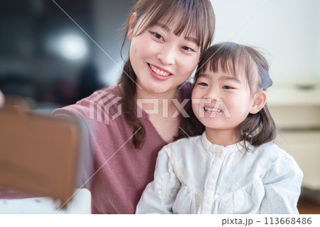 スマートフォンで自撮りをする親子 女の子とお母さん スマートフォンで自撮りをする親子 女の子とお母さん 113668486