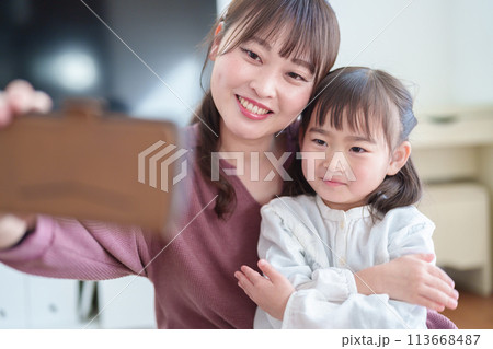 スマートフォンで自撮りをする親子 女の子とお母さん スマートフォンで自撮りをする親子 女の子とお母さん 113668487