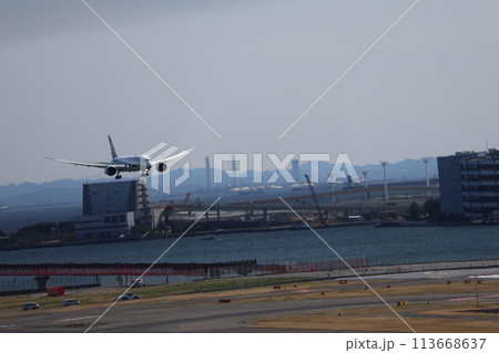着陸態勢の飛行機が降りてくる空港と海と街並みの風景 着陸態勢の飛行機が降りてくる空港と海と街並みの風景 113668637