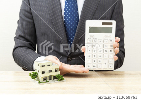 電卓を持つビジネスマンと住宅模型 113669763