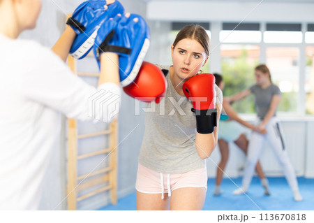 Teen girl in punch mitts boxing 113670818